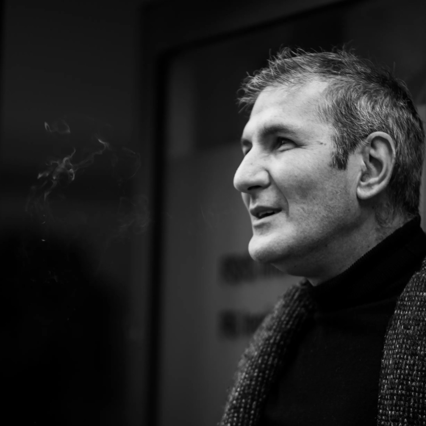 Andrea de profil, une cigarette à la main, fumée s'élevant