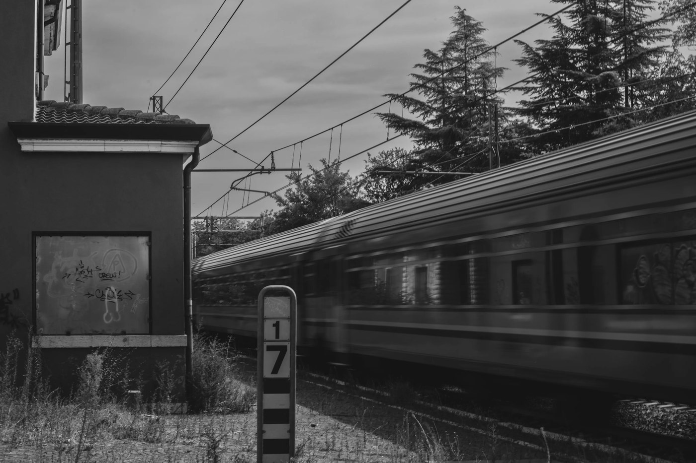 Un train passe en flou de mouvement devant une gare abandonnée